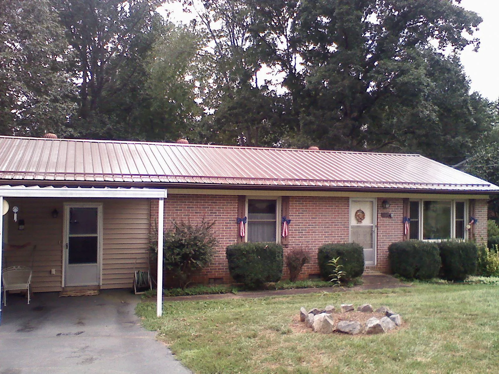 Bronze metal roof and carport on a brick ranch home — Roof Repair work by our crew in Waddell